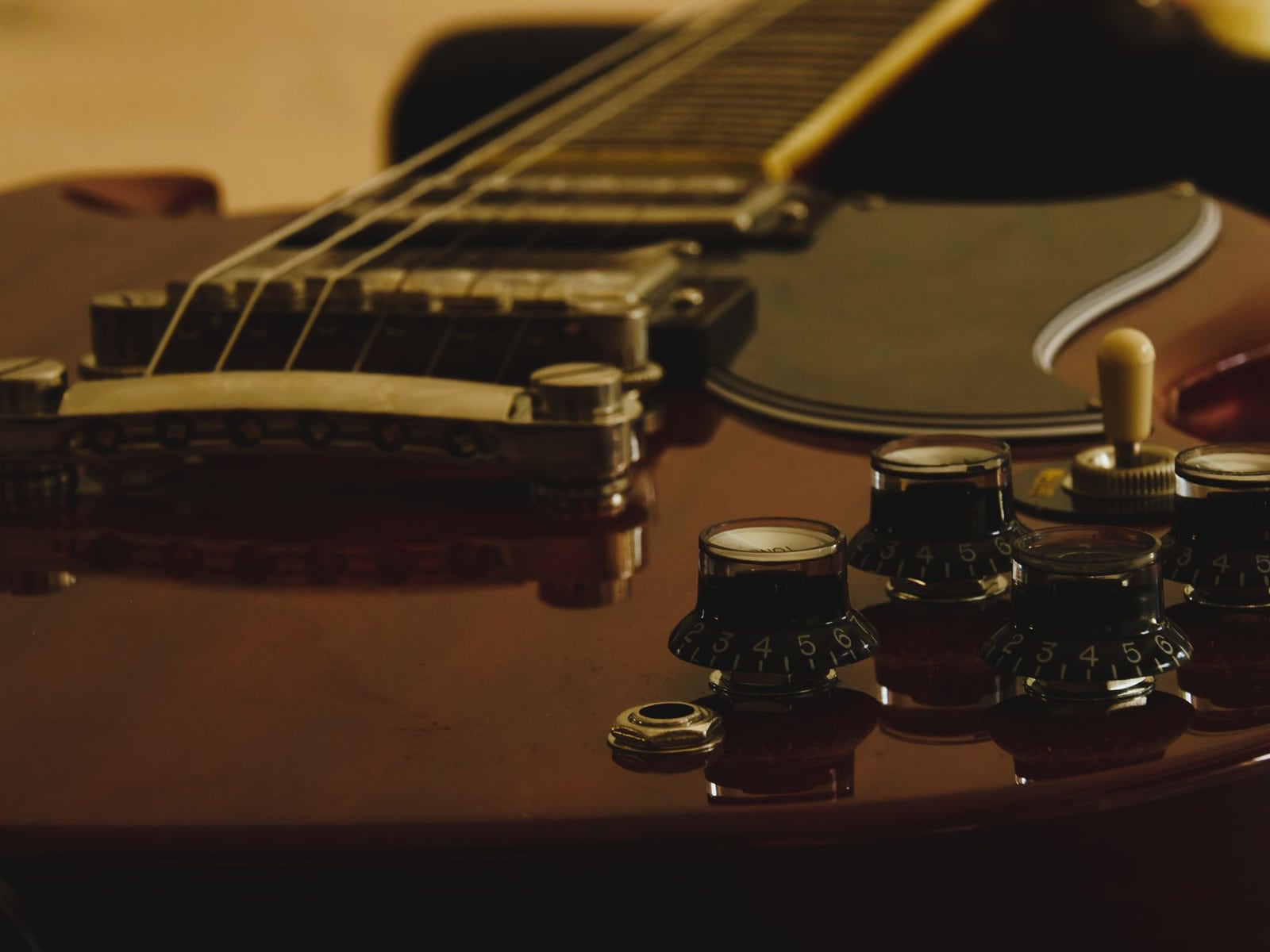 Close-up of a professional adjusting a guitar bridge for precision setup