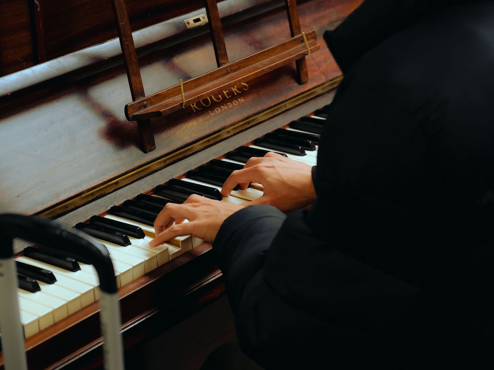 Professional piano tuner working on a grand piano in a residential setting