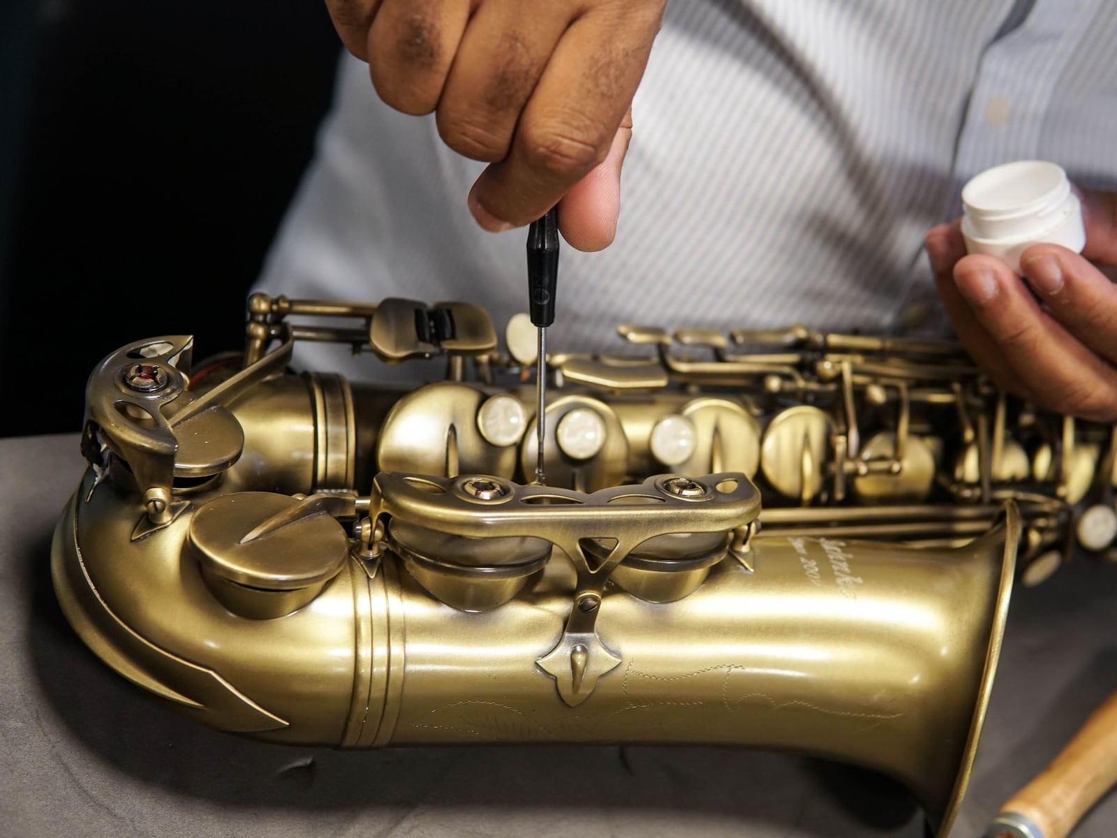 Detailed cleaning and polishing of a brass saxophone in the workshop
